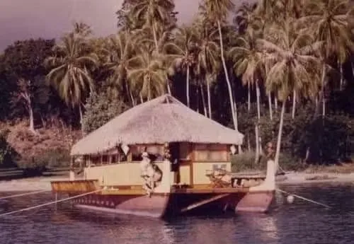 Don the Beachcomber's Marama houseboat on Moorea lagoon with pandanus roofing.